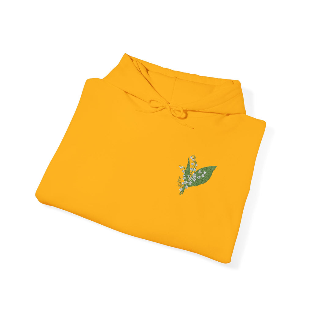 Gold hoodie flat lay, hood with drawstrings and green leaf embroidery on chest