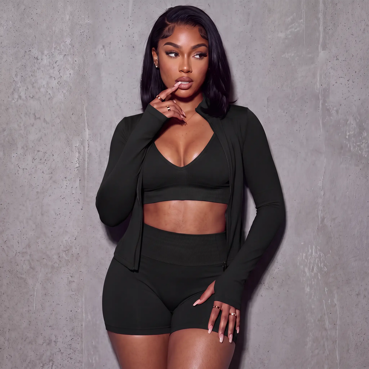 Women’s black 3-piece active set: V-neck sports bra, bike shorts, zip jacket with thumb holes.