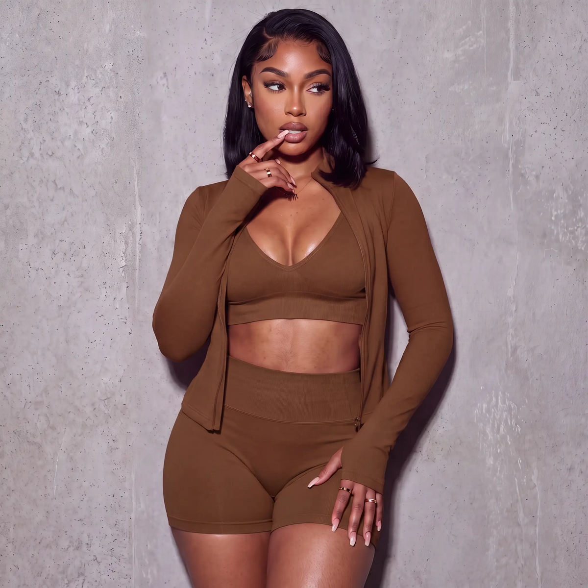 Women’s brown 3-piece active set: V-neck sports bra, bike shorts, zip jacket with thumb holes.