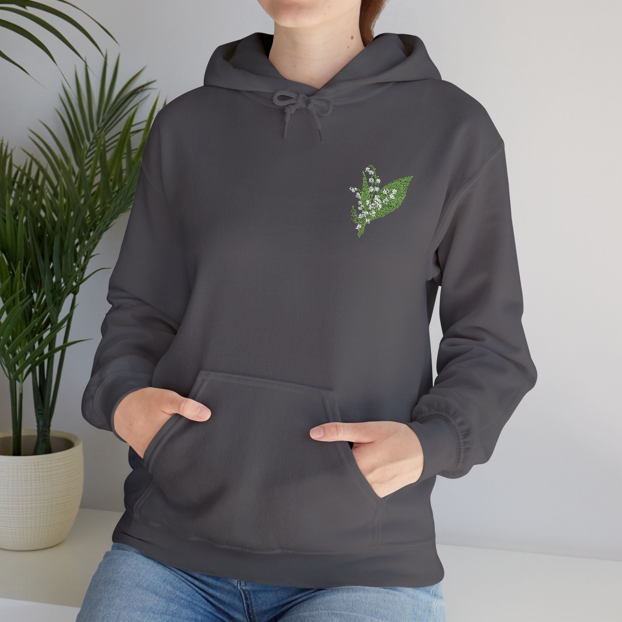 Charcoal hooded sweatshirt with green leaf embroidery on chest, front view