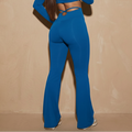 Blue high-waisted active pants with flared legs and cross-back waist cutout
