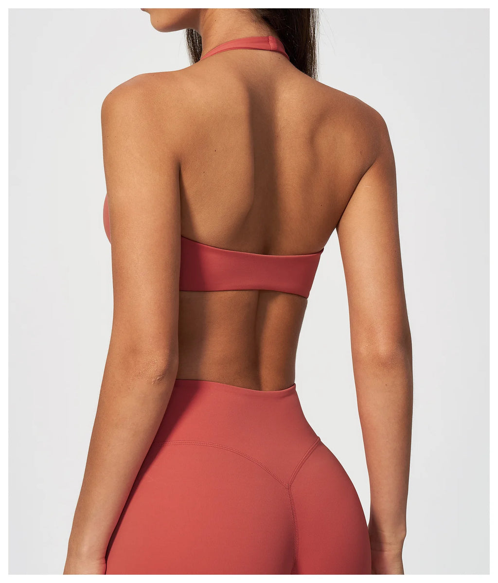 Back view of coral red halter yoga bra with open back band