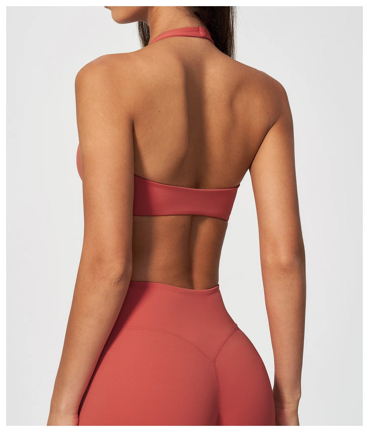 Back view of coral red halter yoga bra with open back band