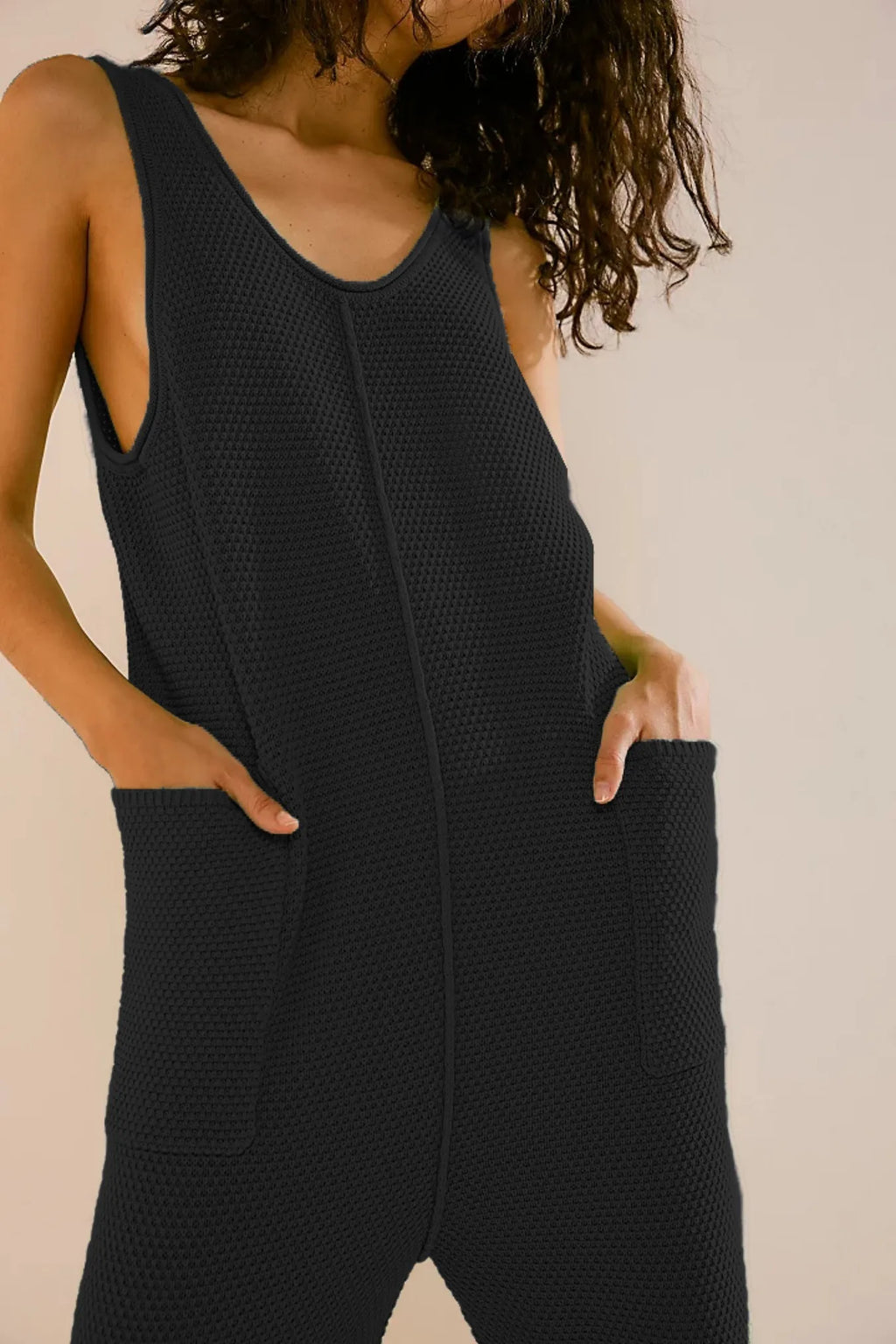 Black knit wide-leg romper with scoop neck, side pockets, relaxed fit