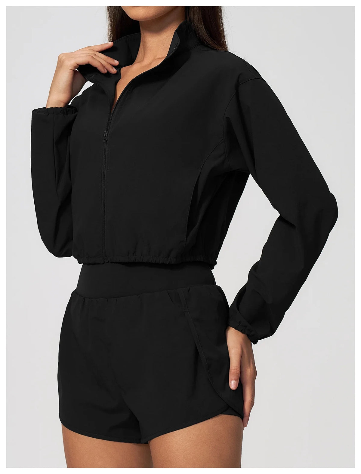 Black zip-up long sleeve workout jacket with front zipper and elastic waistband