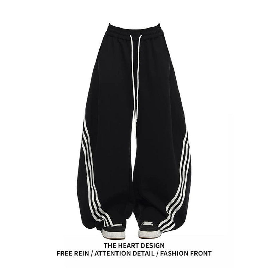 Black wide-leg sweatpants with white side stripes and elastic drawstring waist