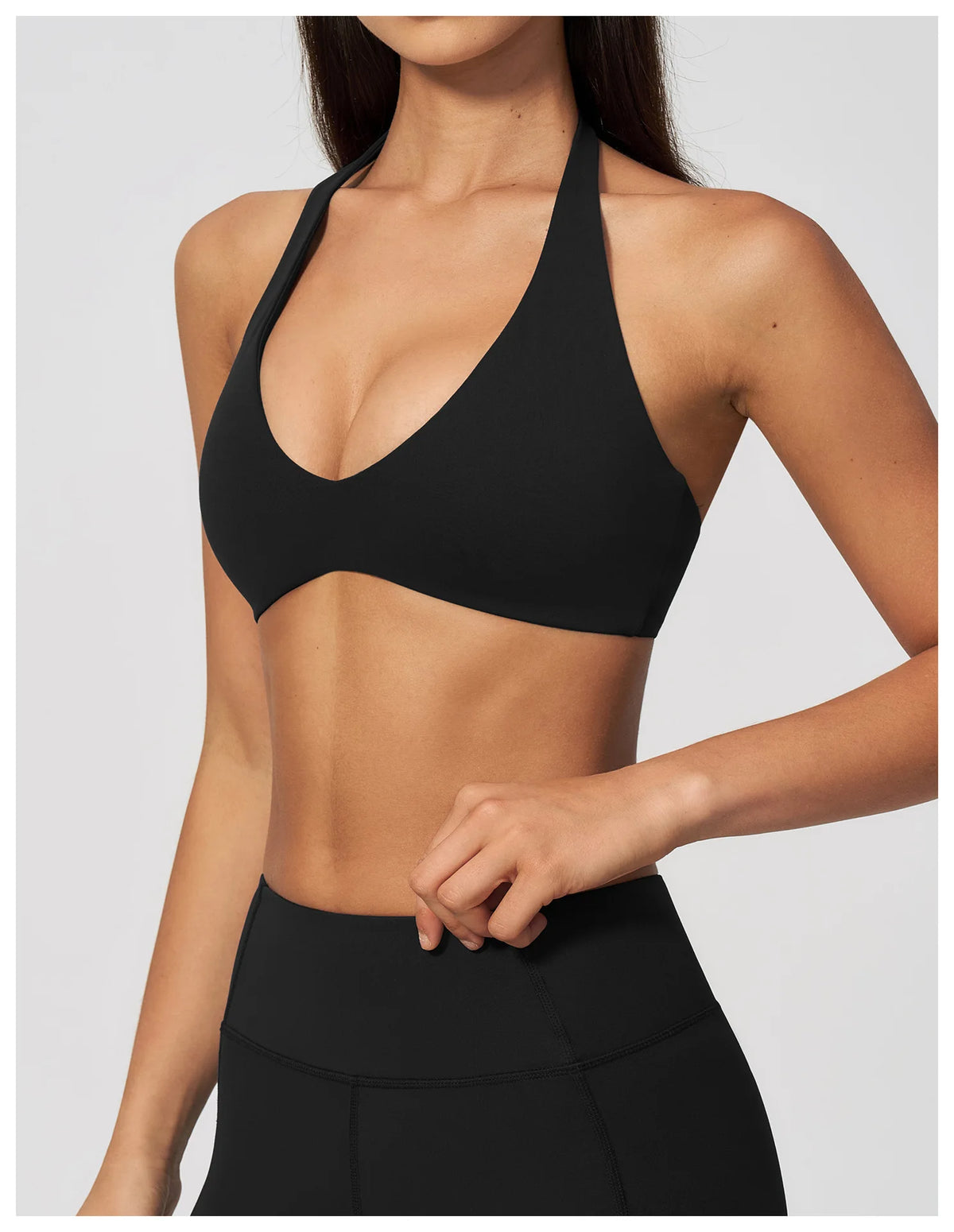 Black halter sports bra with V plunge neckline, close-up front detail