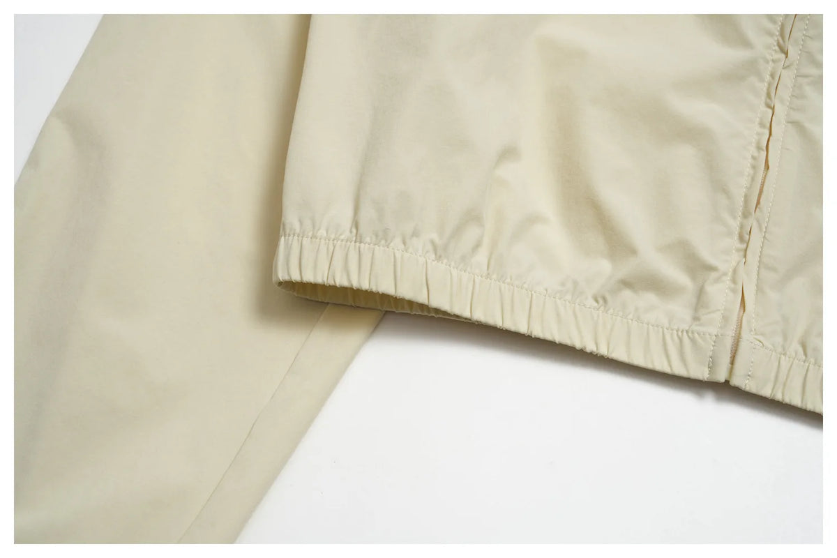 Cream cropped yoga jacket sleeve hem with elastic band and stitched edge