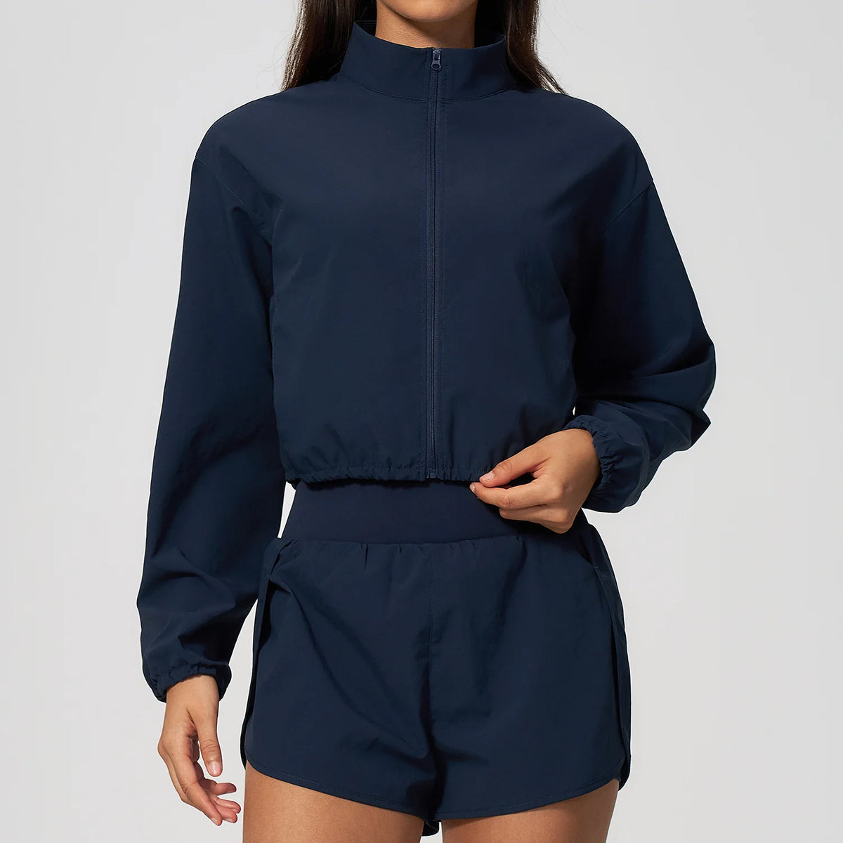 Indigo blue zip-front women's sports jacket with stand collar and long sleeves