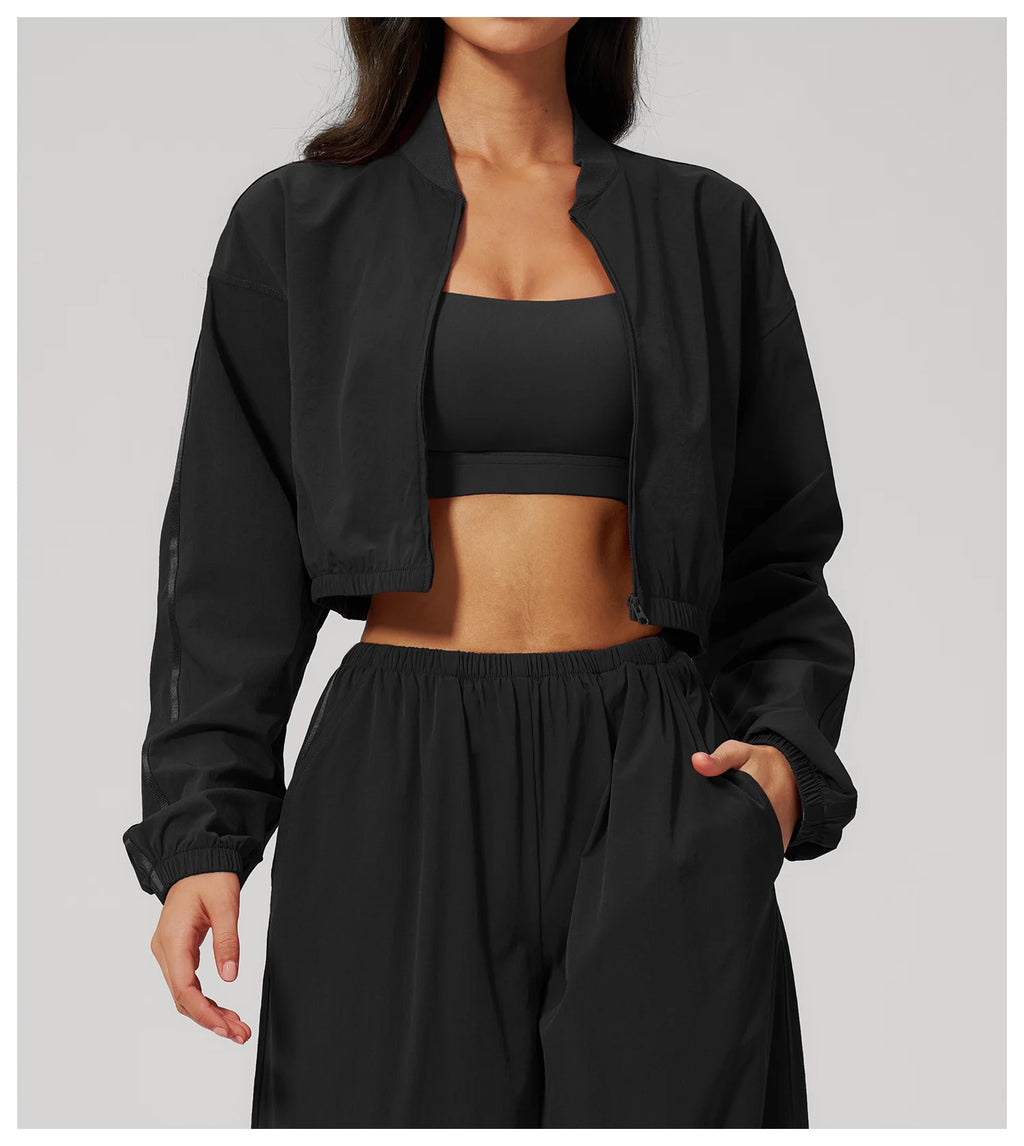 Women’s cropped yoga jacket in black with open front, long sleeves, and zipper