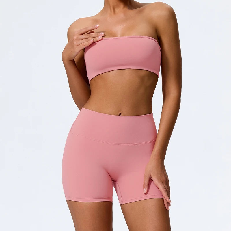 Two-piece fitness set with coral pink strapless bandeau bra and matching biker shorts