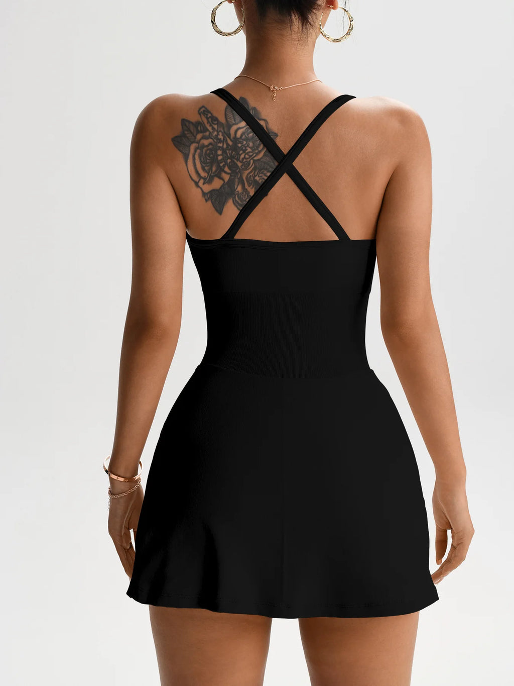 Black one-piece tennis skort dress shown from back with crisscross straps and open cutout