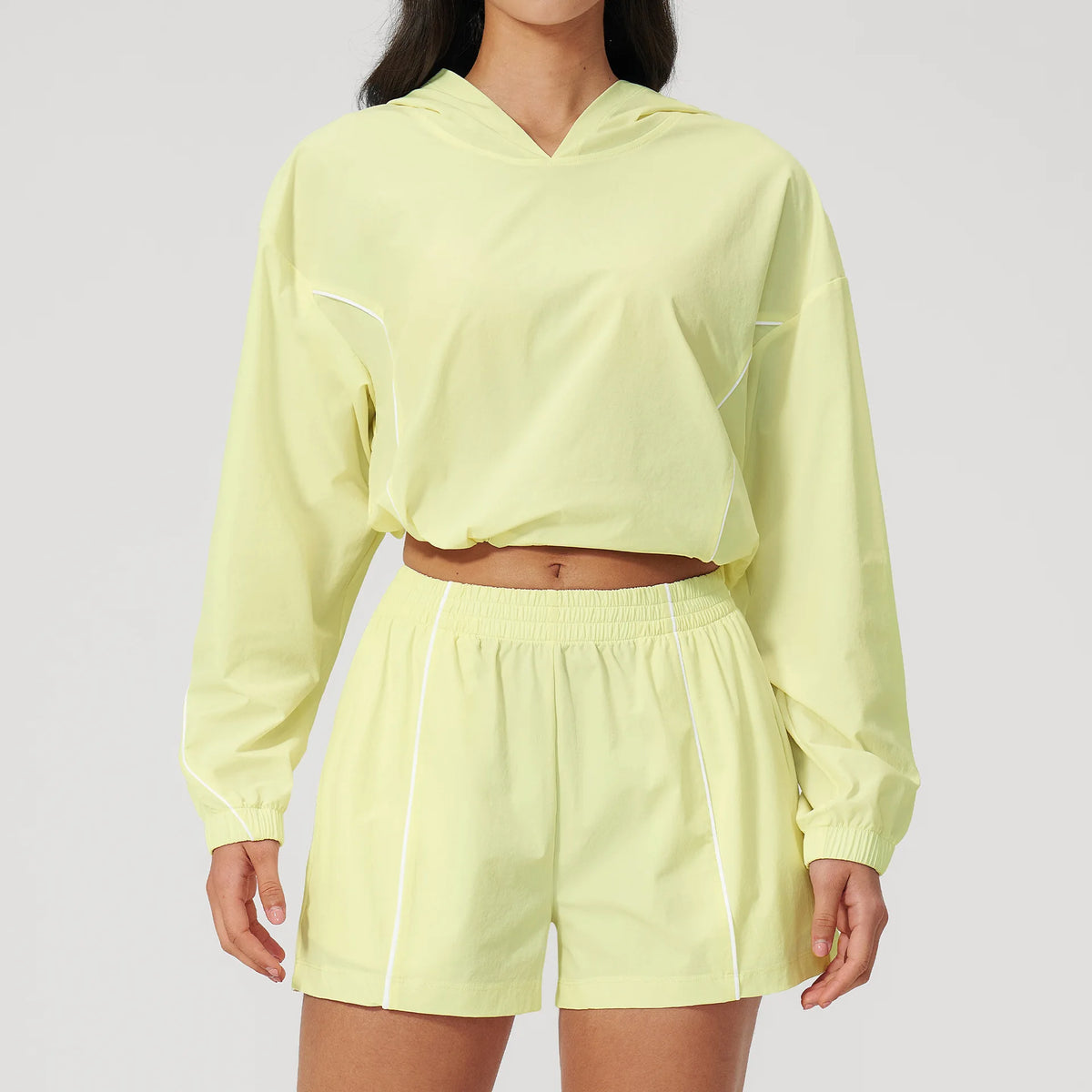 Women’s hooded sports set in light yellow, cropped jacket and matching shorts