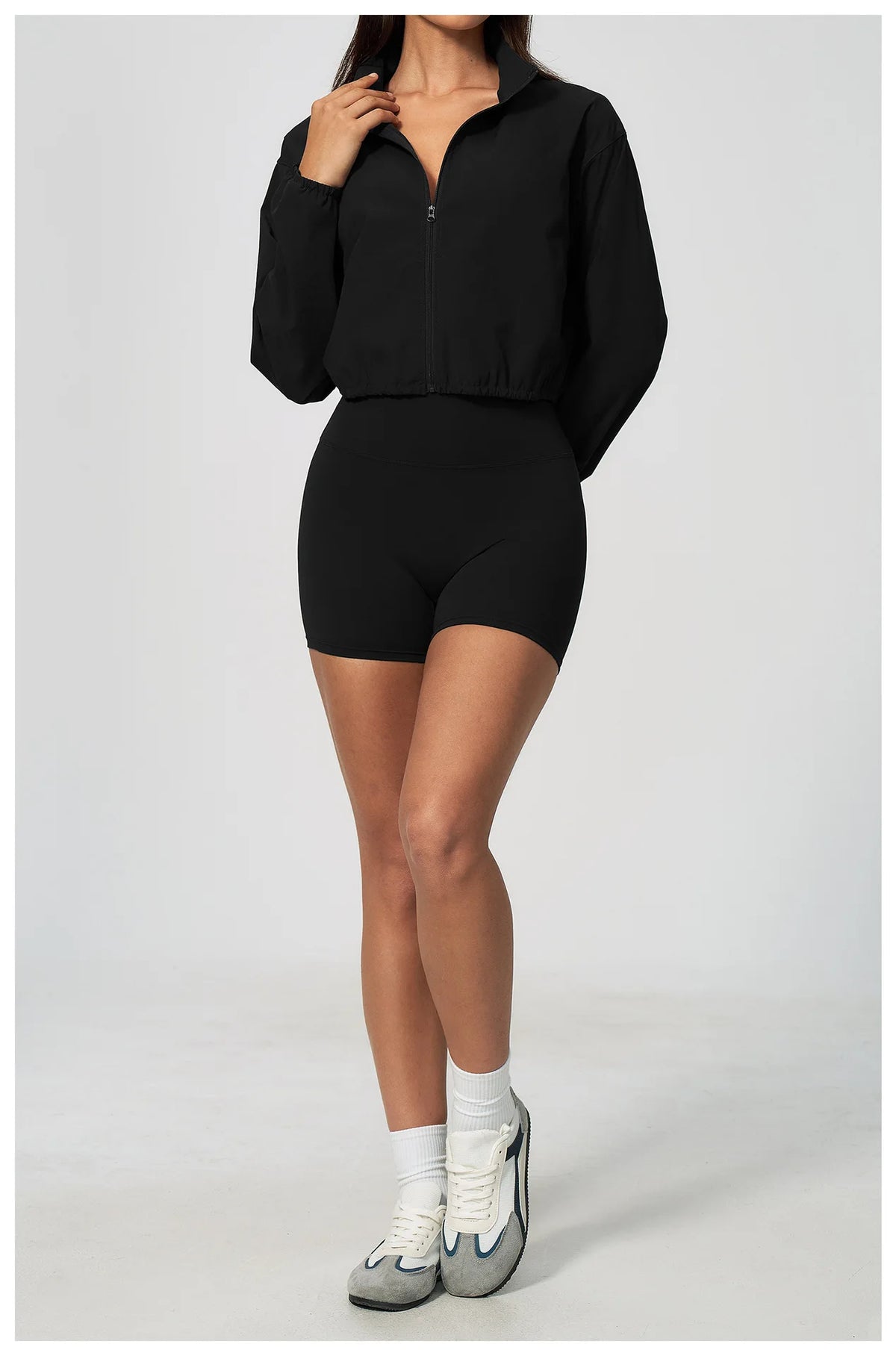 Black zip-up athletic jacket with stand collar and long sleeves, elastic waist