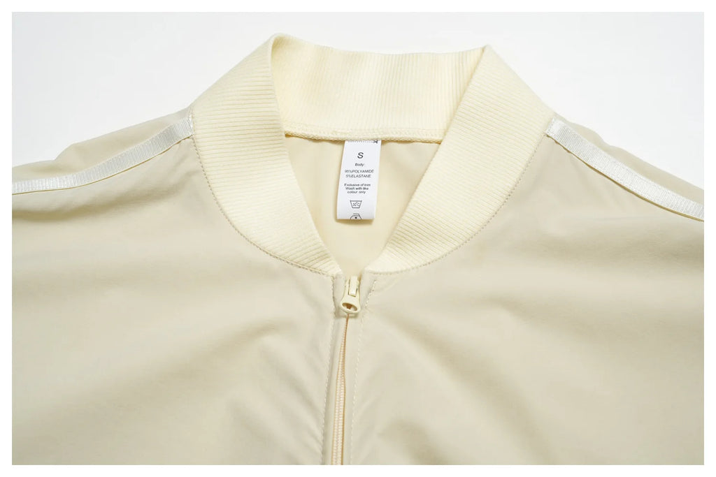 Women’s zip-up athletic jacket, light cream with stand collar and gold zipper
