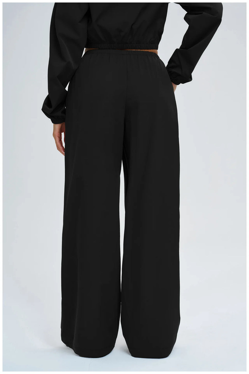 Women’s black loose wide-leg pants with elastic waistband and full-length silhouette.