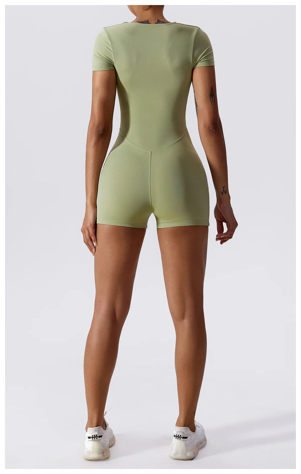 Light green short-sleeve one-piece yoga suit with back seam and fitted shorts