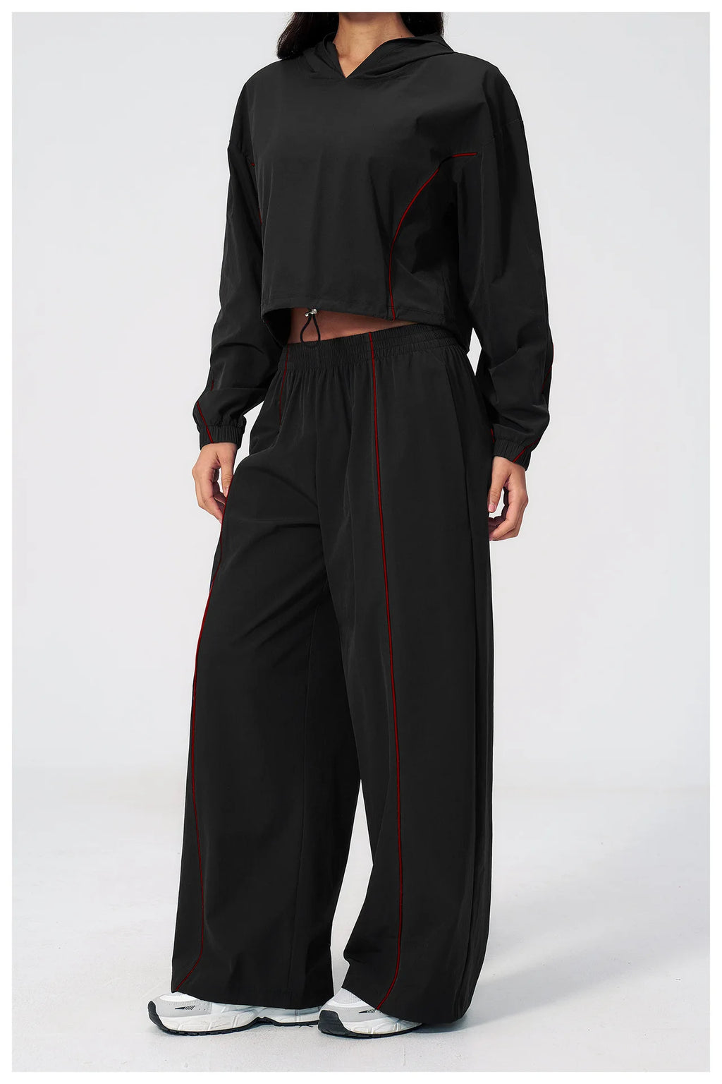 Women’s black hooded windbreaker and matching wide-leg pants set with red piping