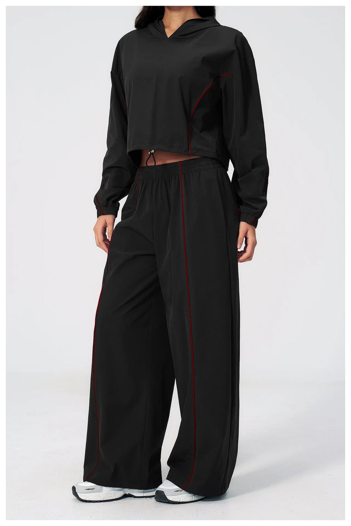 Women’s black hooded windbreaker and matching wide-leg pants set with red piping