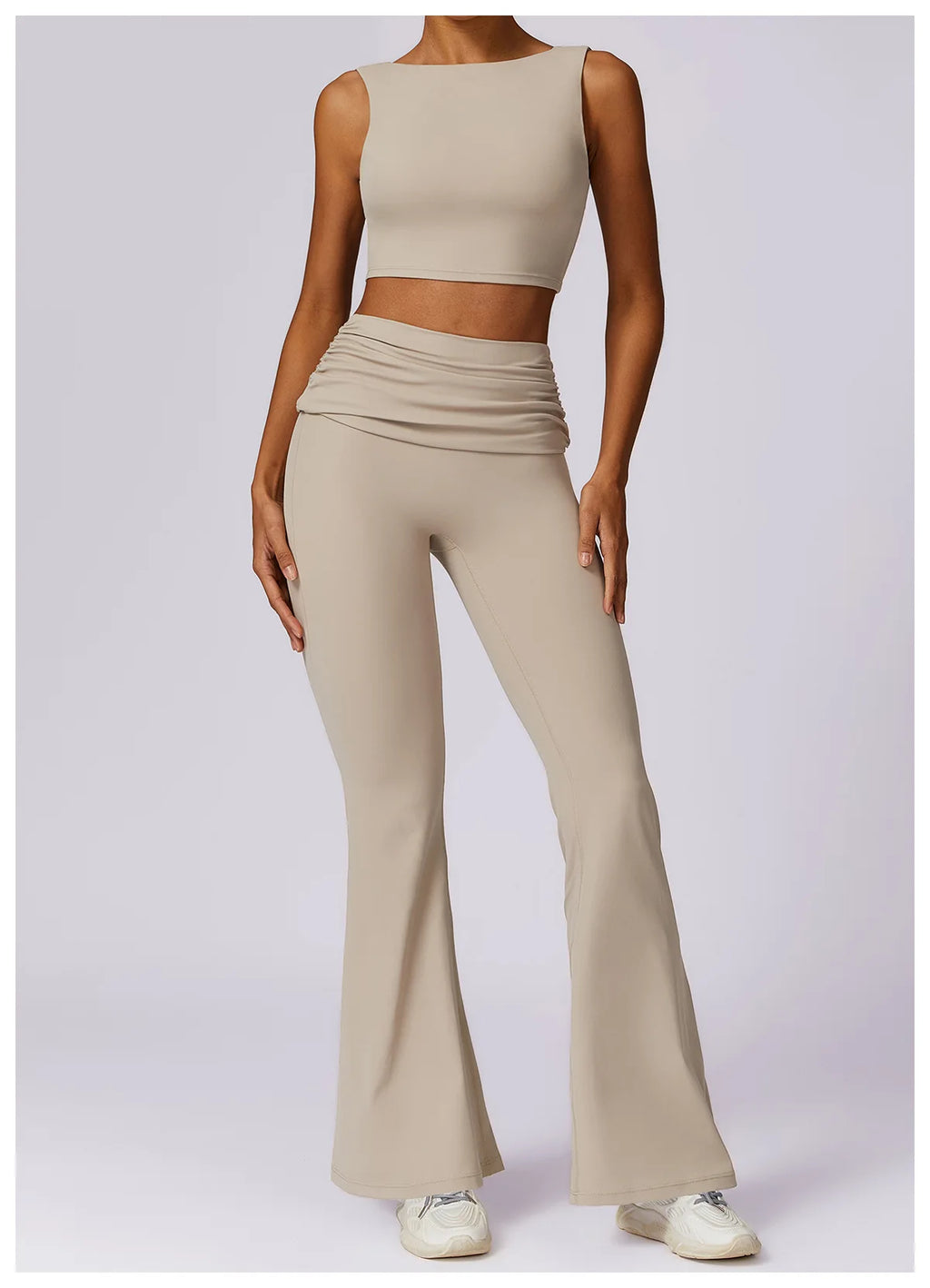 Beige sleeveless sports bra crop top with high neckline and smooth fabric.