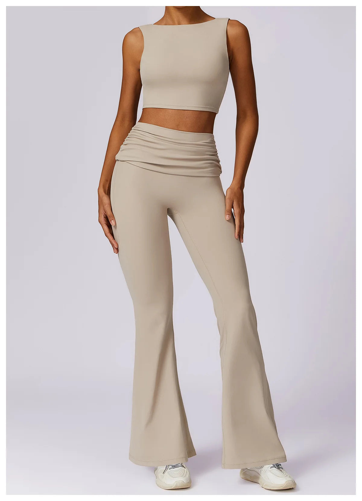 Beige sleeveless sports bra crop top with high neckline and smooth fabric.