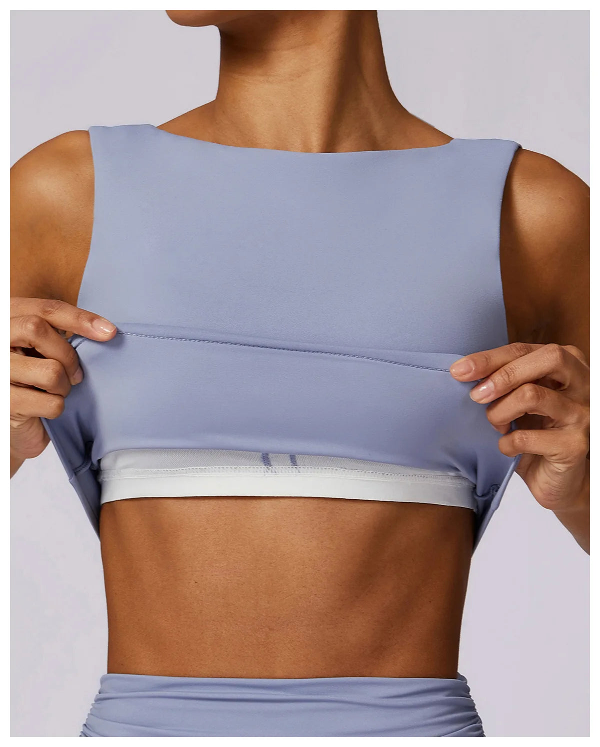 Light blue sports bra crop top with elastic bottom band and smooth stretch fabric.