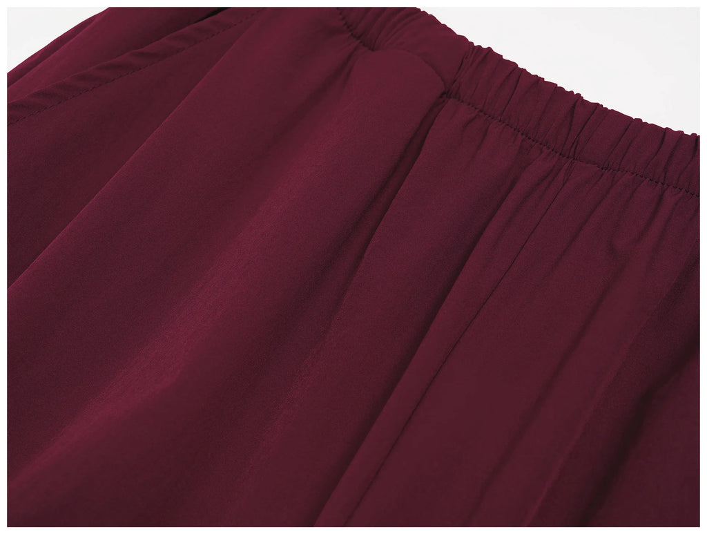 Women's burgundy wide-leg sports pants with elastic waistband and pleated front
