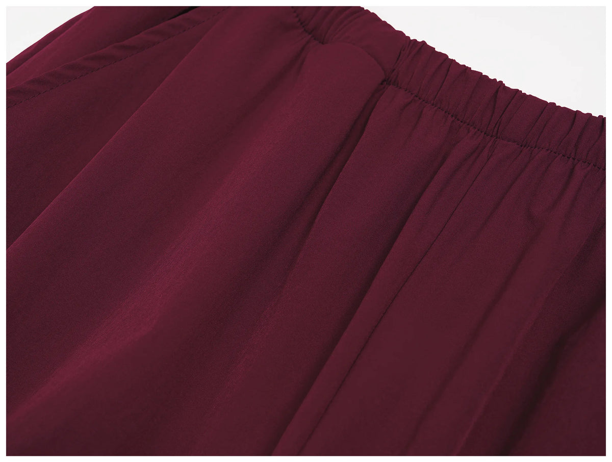Women's burgundy wide-leg sports pants with elastic waistband and pleated front