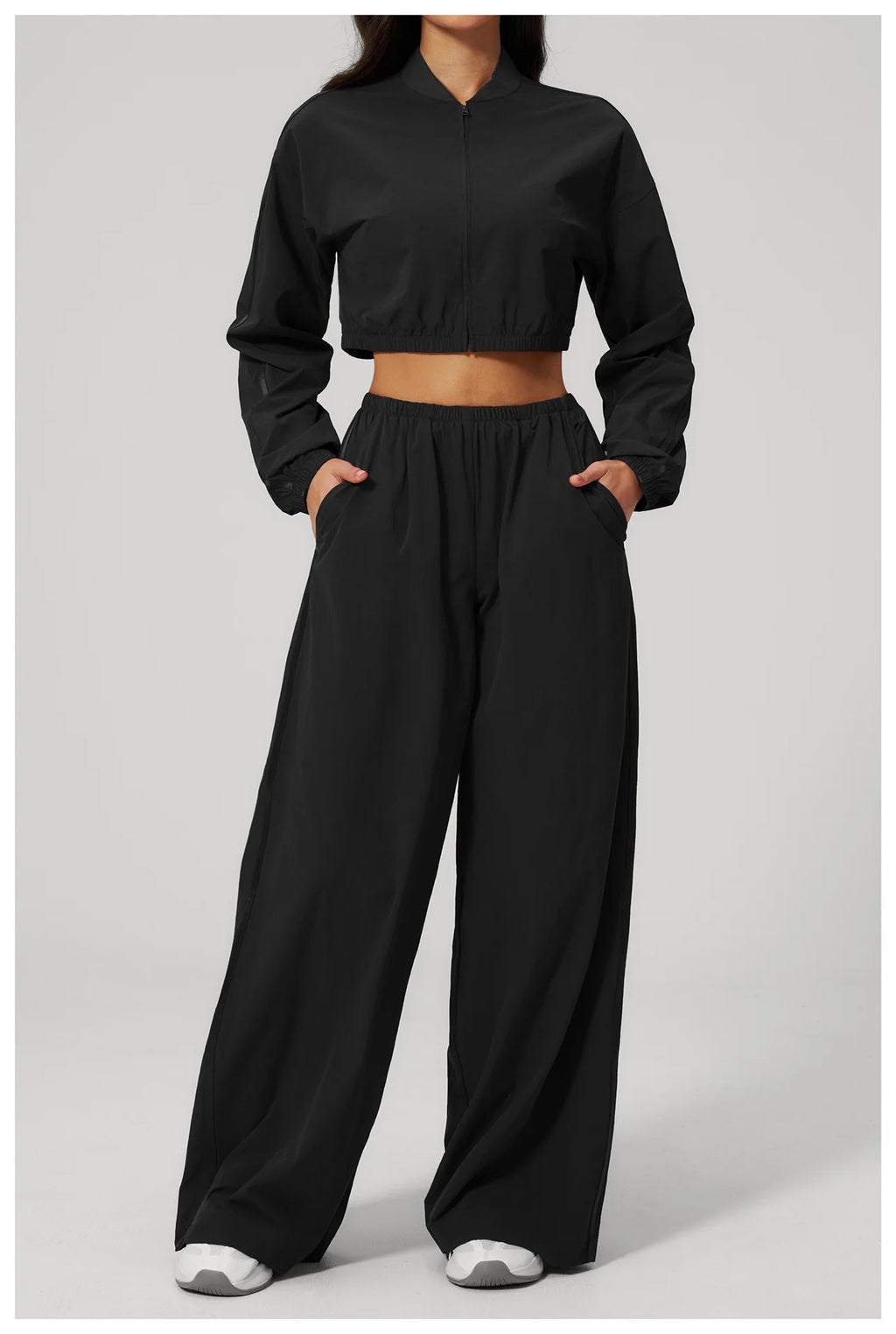 Women’s cropped yoga jacket in black, front view with stand collar and zip-up design