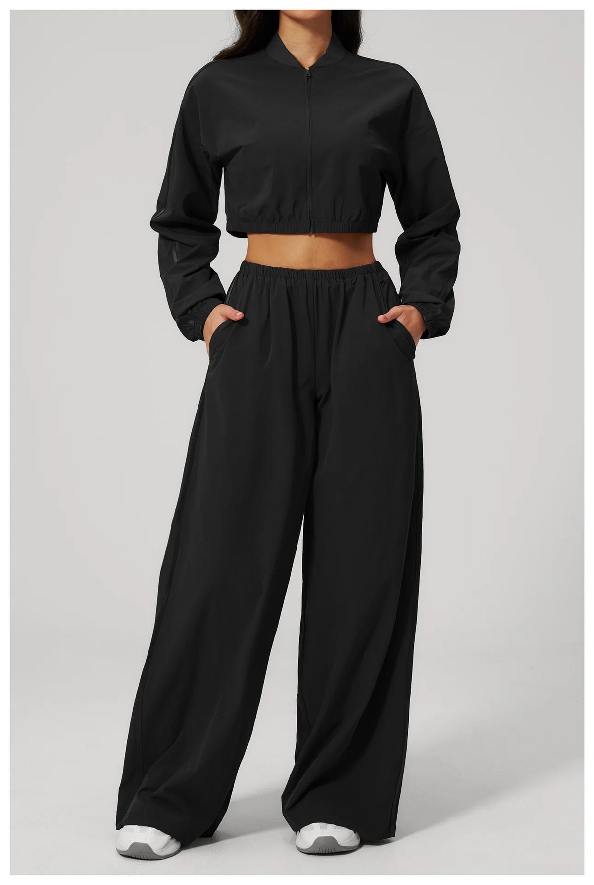 Women’s cropped yoga jacket in black, front view with stand collar and zip-up design