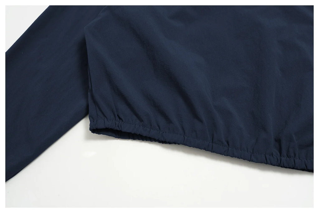 Indigo blue zip jacket with gathered elastic hem and smooth fabric finish