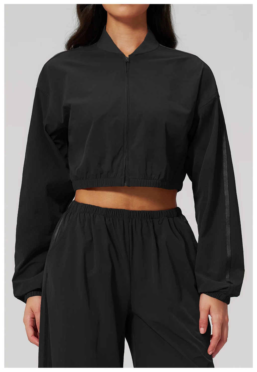 Women’s cropped yoga jacket in black with front zipper and elastic waist hem