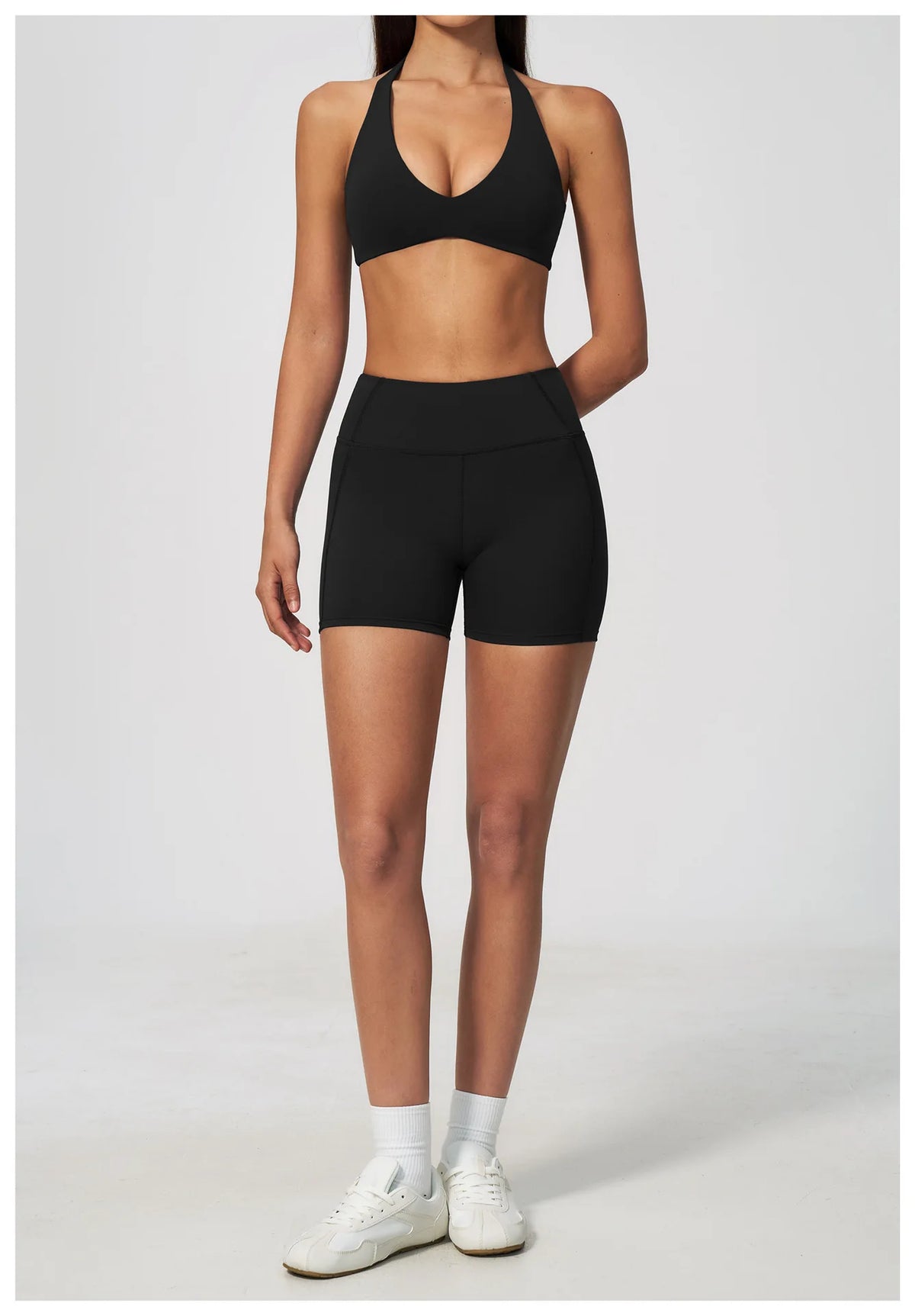 Black halter yoga sports bra with V plunge front and matching high-waist shorts look