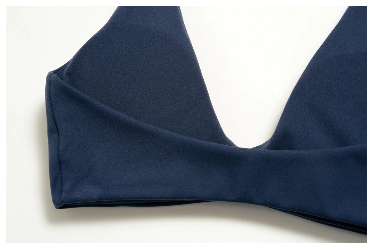 Navy halter sports bra detail with wide strap and smooth curved seam