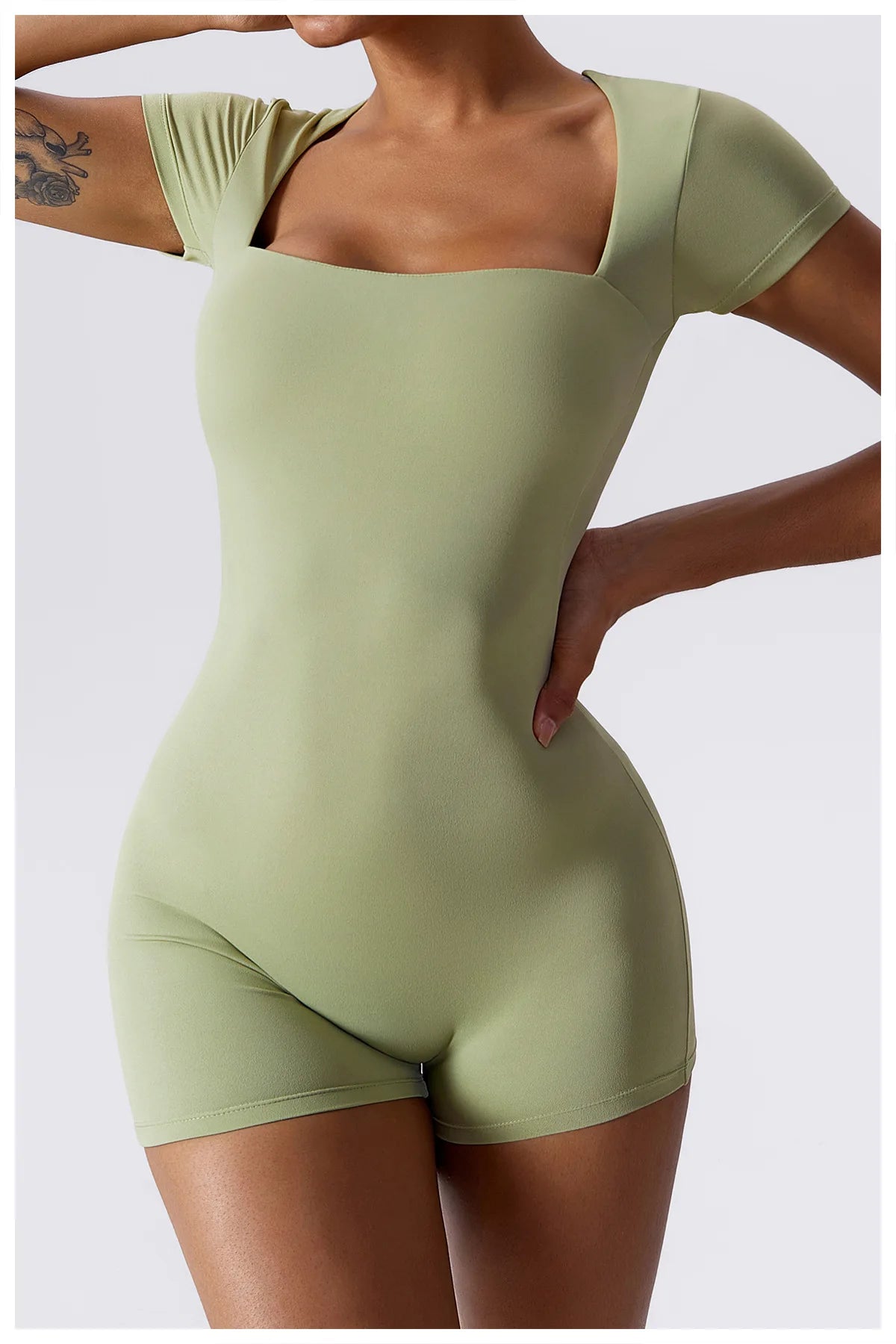 Light green short-sleeve one-piece yoga suit with scoop neckline and fitted shorts