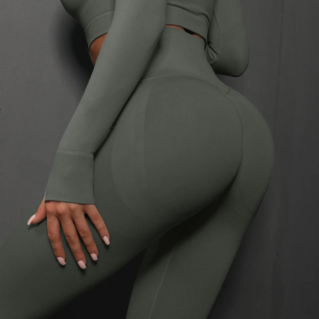 High-waist green yoga leggings with supportive curved back panel and fitted legs.