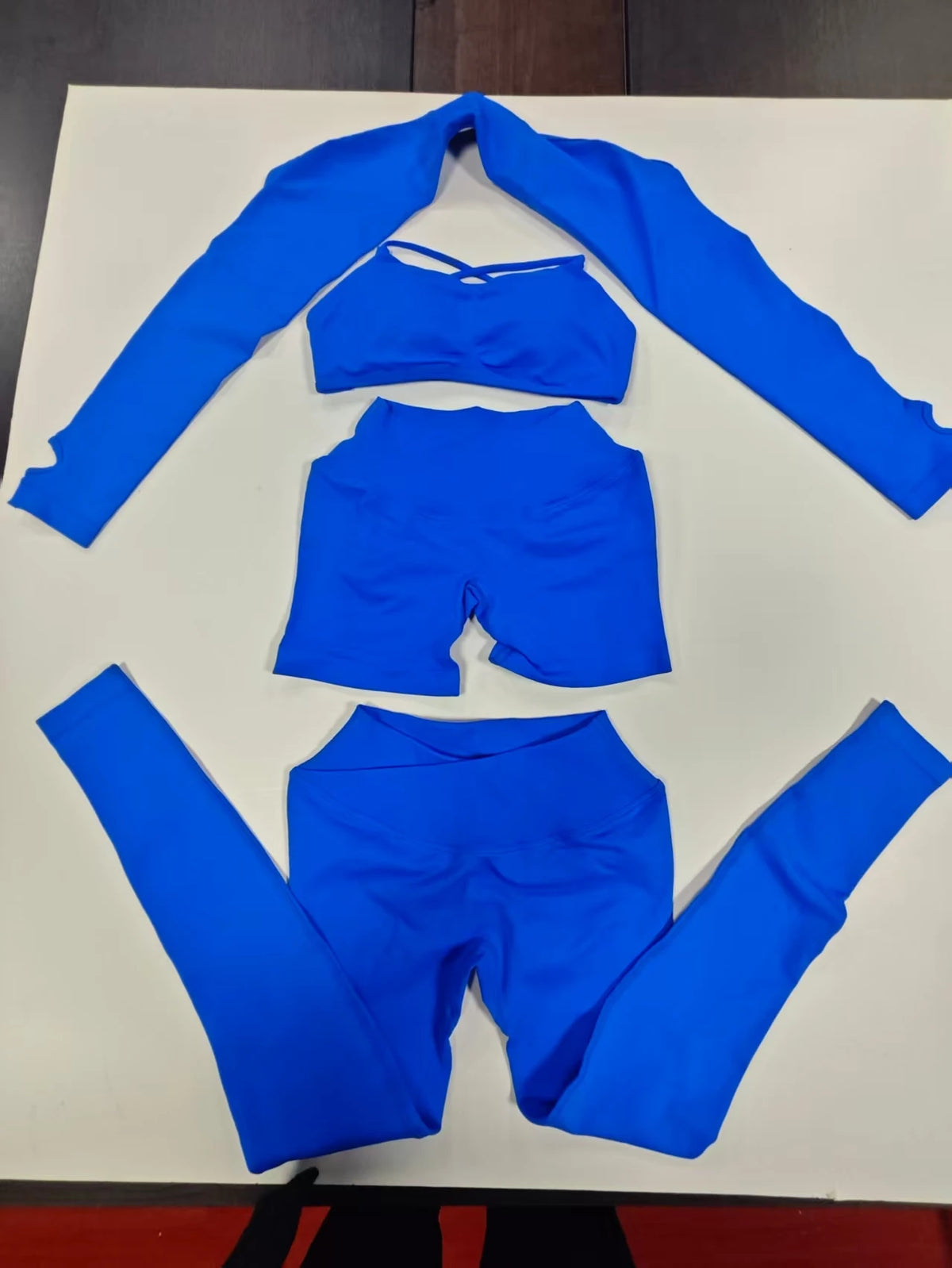 Glacier blue seamless workout set flat lay: shrug, sports bra and leggings
