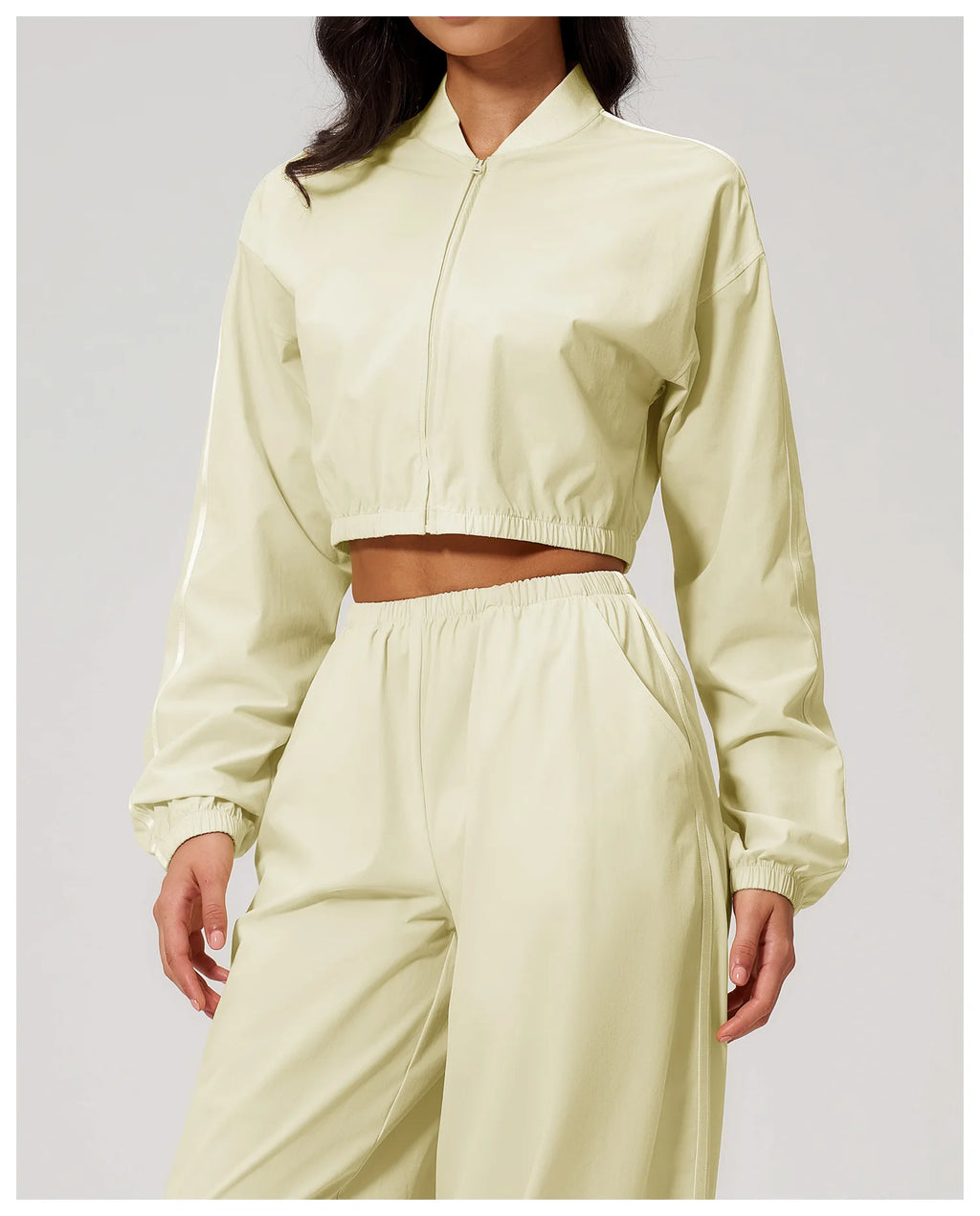 Women’s cropped almond yellow zip-up jacket, front view with elastic waist.