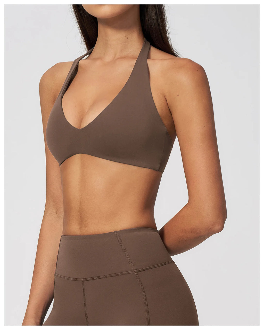 Dark brown halter neck sports bra with V neckline, sleeveless cropped gym top
