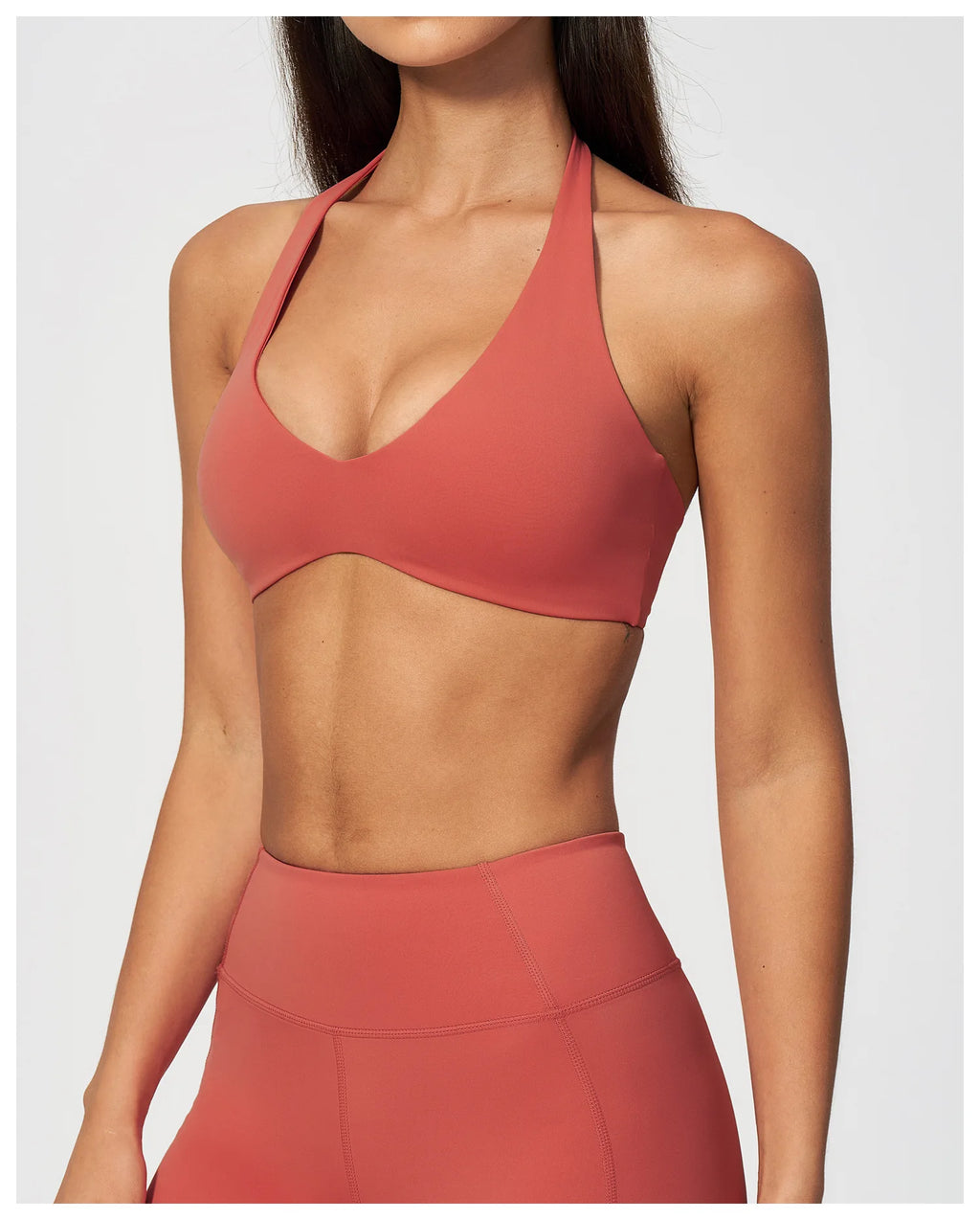 Coral red halter sports bra with deep V neckline and racerback silhouette