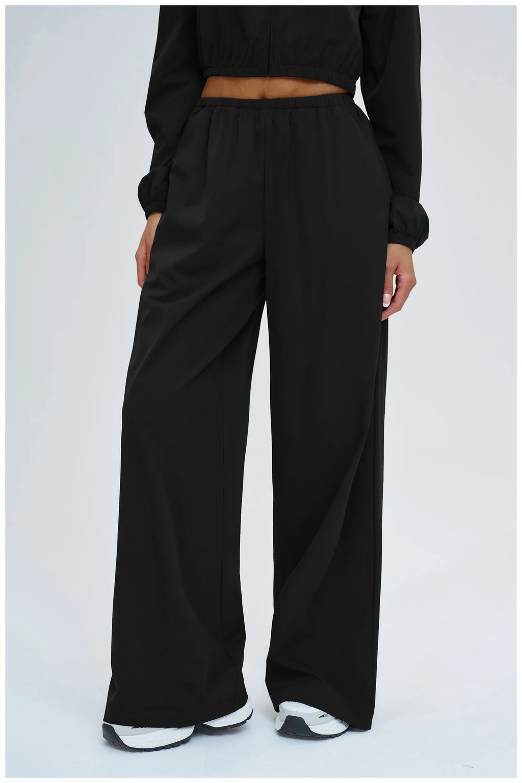 Women’s black wide-leg trousers with elastic waist and roomy leg opening.