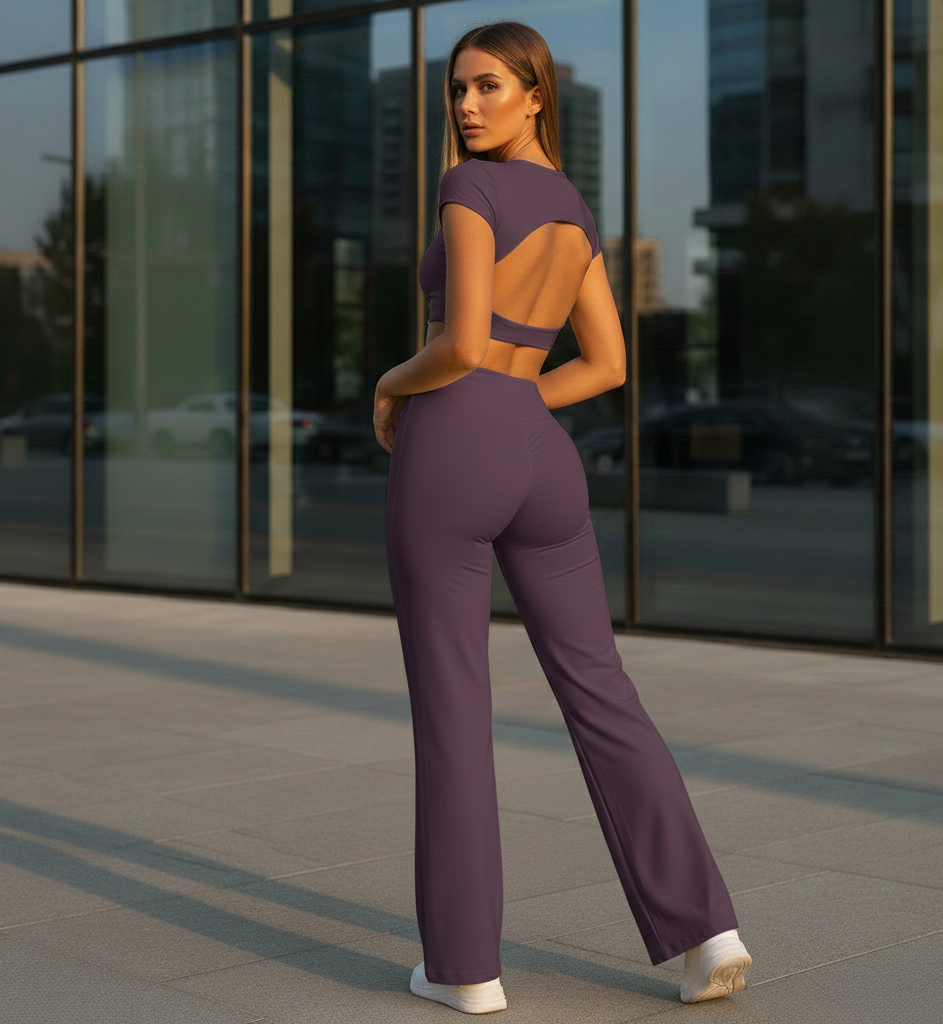 Woman in a purple outfit standing in front of a glass building.