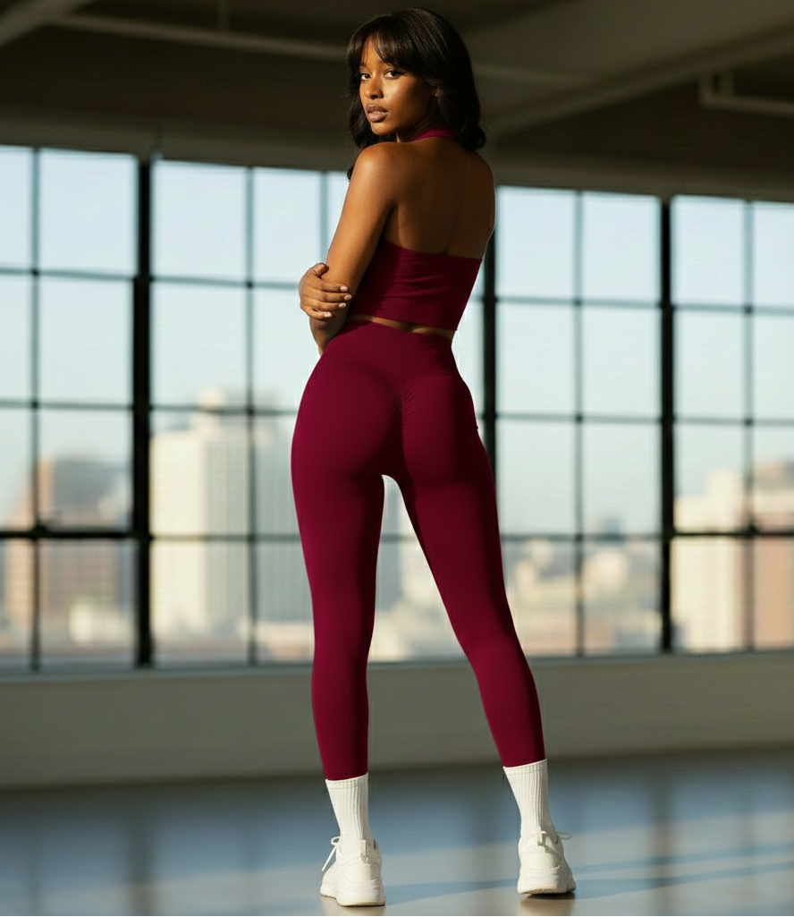 Woman in a red outfit standing in a room with large windows