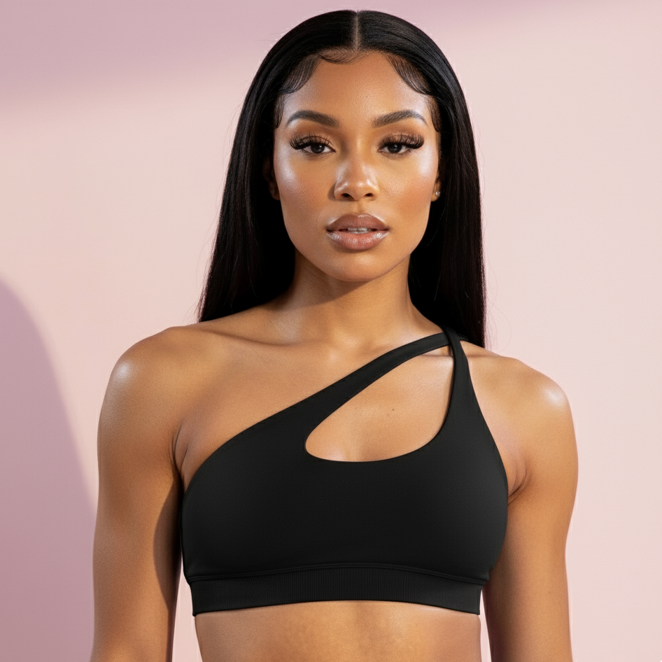 Woman wearing a black sports bra against a pink background