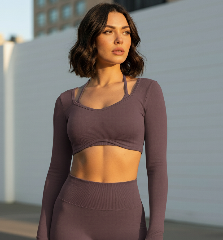 Woman wearing a brown long-sleeve athletic top and leggings outdoors.