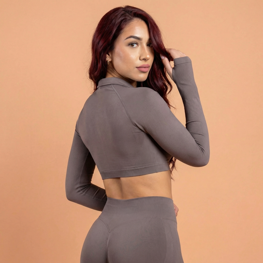 Woman wearing a brown long-sleeve crop top and leggings against a beige background