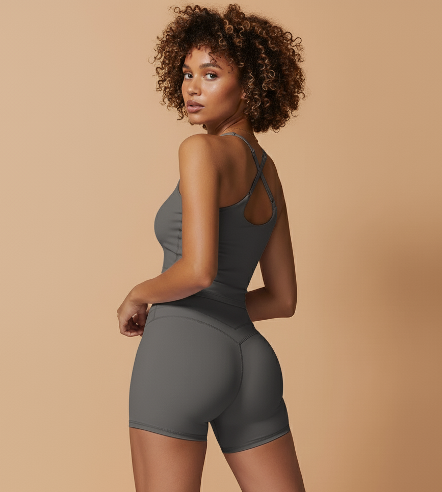 Woman wearing a gray athletic outfit on a beige background