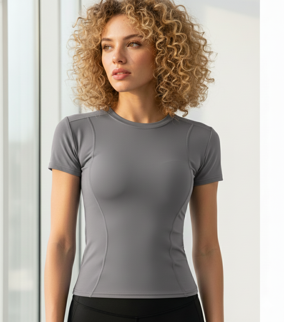 Woman wearing a gray athletic shirt against a light background