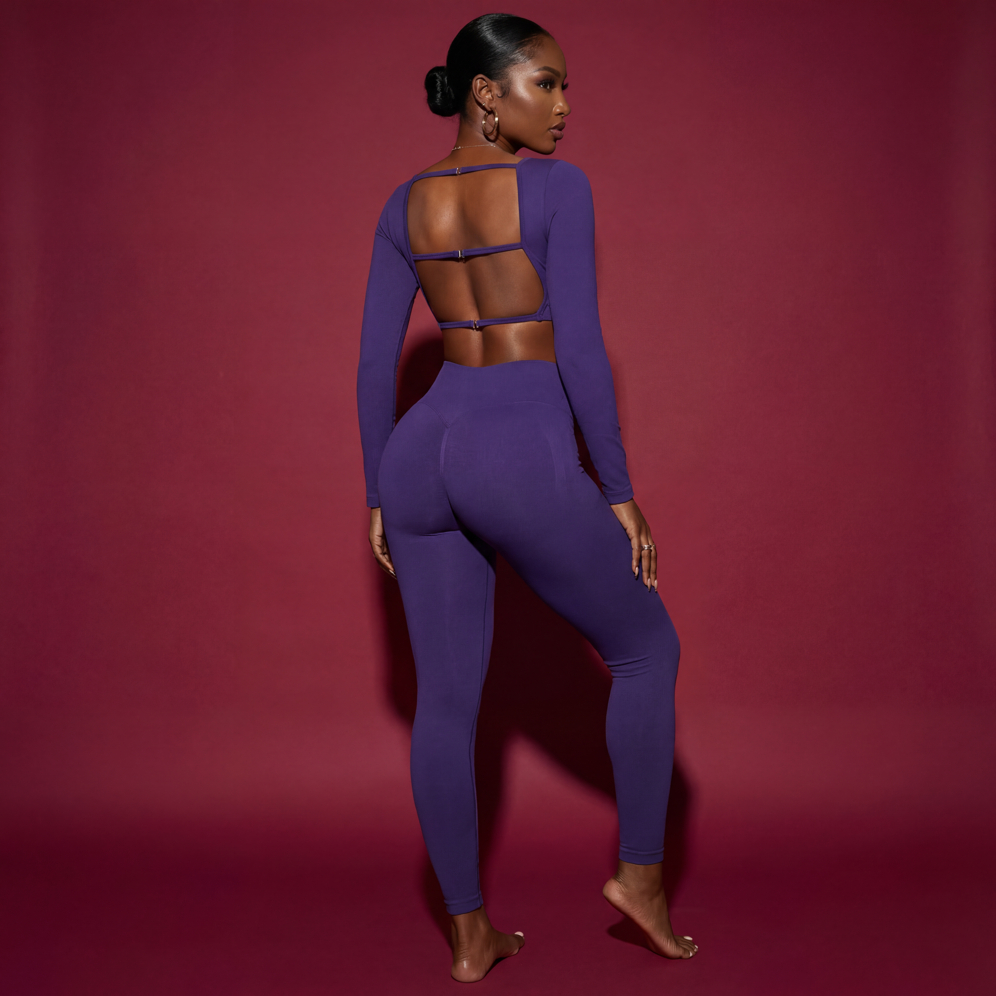 Woman wearing a purple outfit with cut-out design on a red background