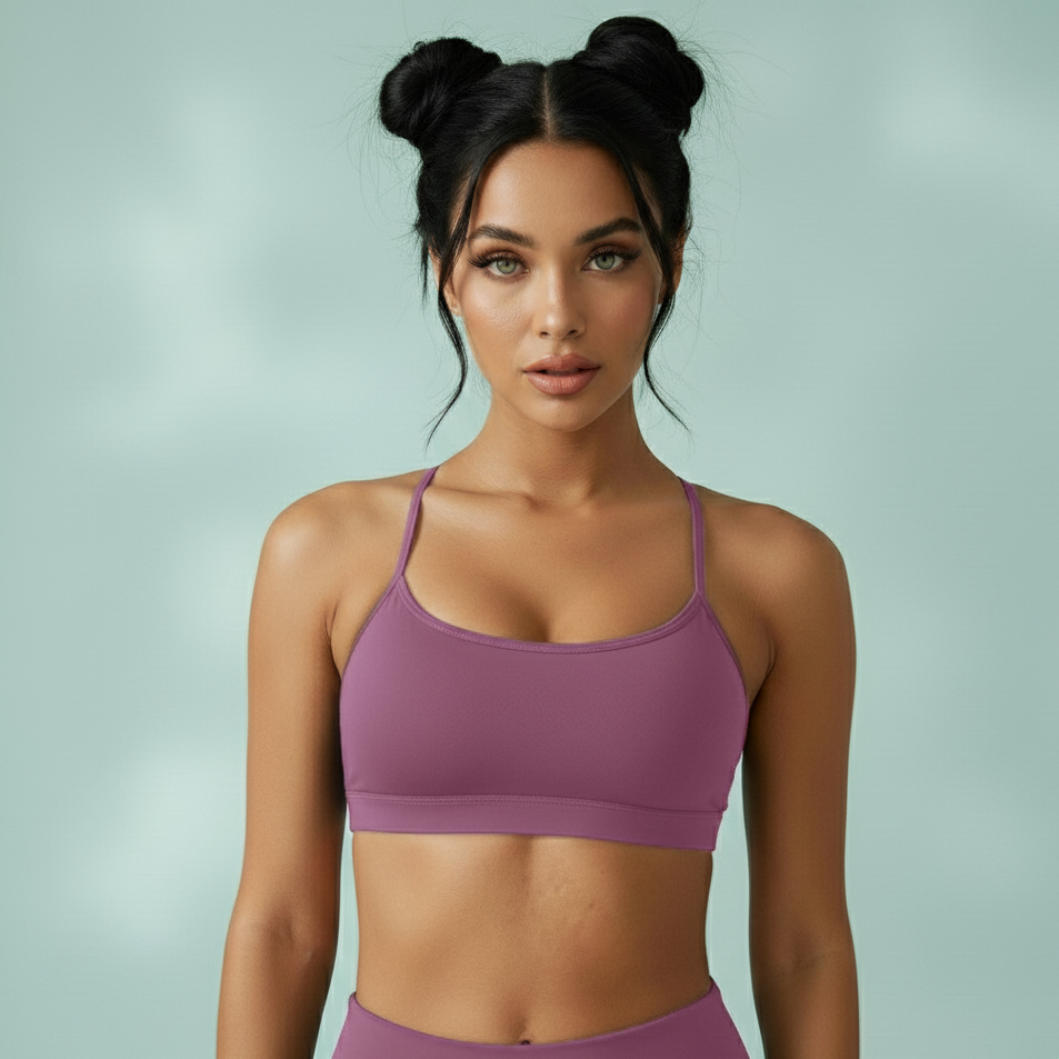 Woman wearing a purple sports bra and leggings against a light green background